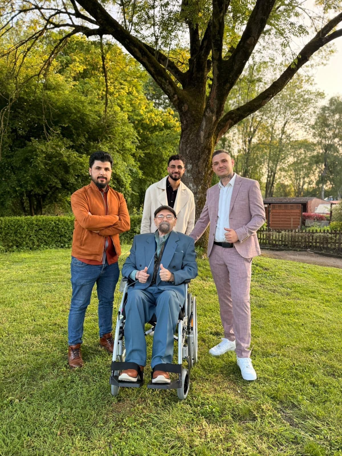 Team der Pflege Intensiv GmbH gemeinsam mit einem Patienten im Rollstuhl im Freien