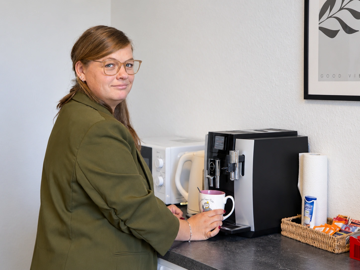 Mitarbeiterin der Pflege Intensiv GmbH holt sich in der Teamküche einen Kaffee